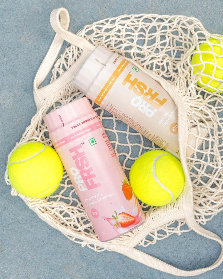 Pro Frsh bottles resting in a woven net bag with tennis balls